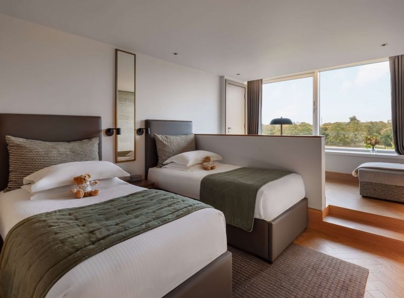The newly refurbished Garden Deluxe Twin room at Royal Garden Hotel featuring stunning views of Kensington Gardens and separate twin beds.