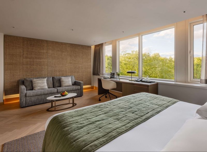 The newly refurbished Deluxe Studio at Royal garden Hotel features a lavish king bed, a comfortable sofa area, a work desk with window view.
